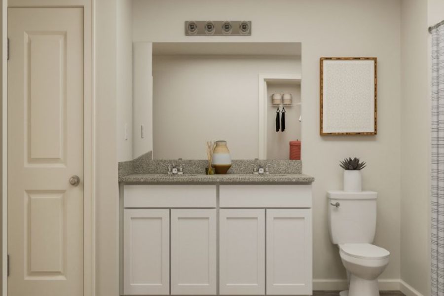 A bathroom with a sink toilet and mirror.