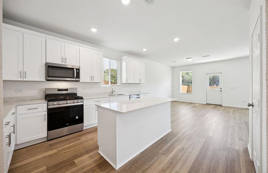 Large island overlooking gathering room and dining areas