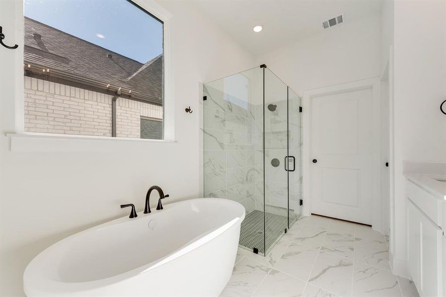 Full bath with a freestanding tub, light marble finish floors, a marble finish shower, vanity, and recessed lighting Full bath with a freestanding tub, light marble finish floors, a marble finish shower, vanity, and recessed lighting