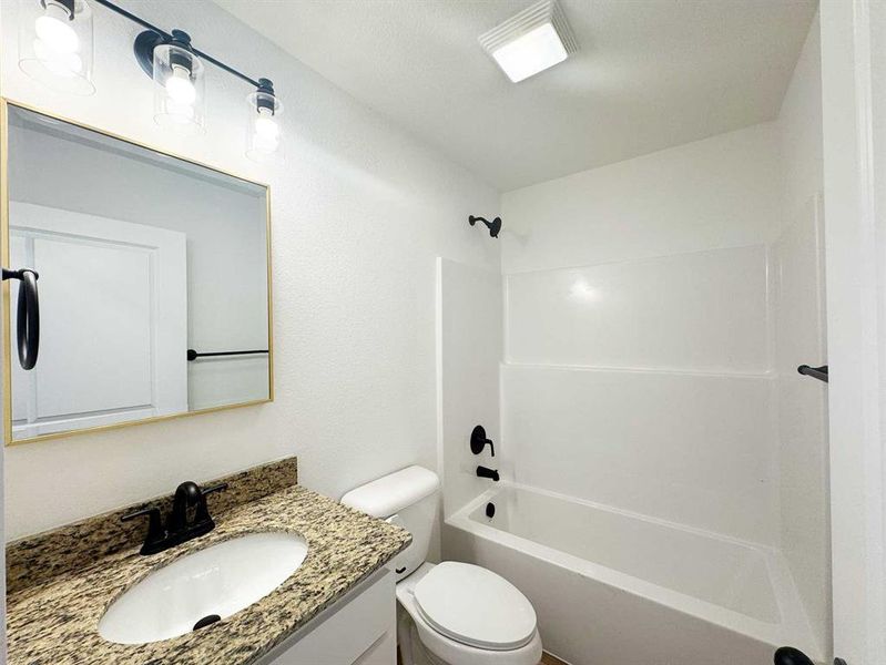 Full bathroom with shower / washtub combination, vanity, and toilet