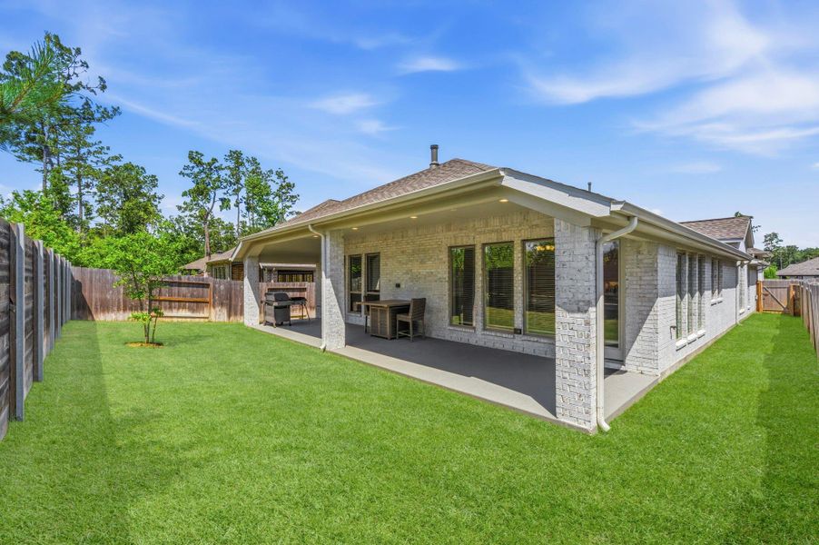 A Great View of the Huge Back Patio Showcasing the Full Brick and Gutters on this Fully Fenced in Back Yard with Sprinkler System and French Drains. No Rear Neighbors A Great View of the Huge Back Patio Showcasing the Full Brick and Gutters on this Fully Fenced in Back Yard with Sprinkler System and French Drains. No Rear Neighbors
