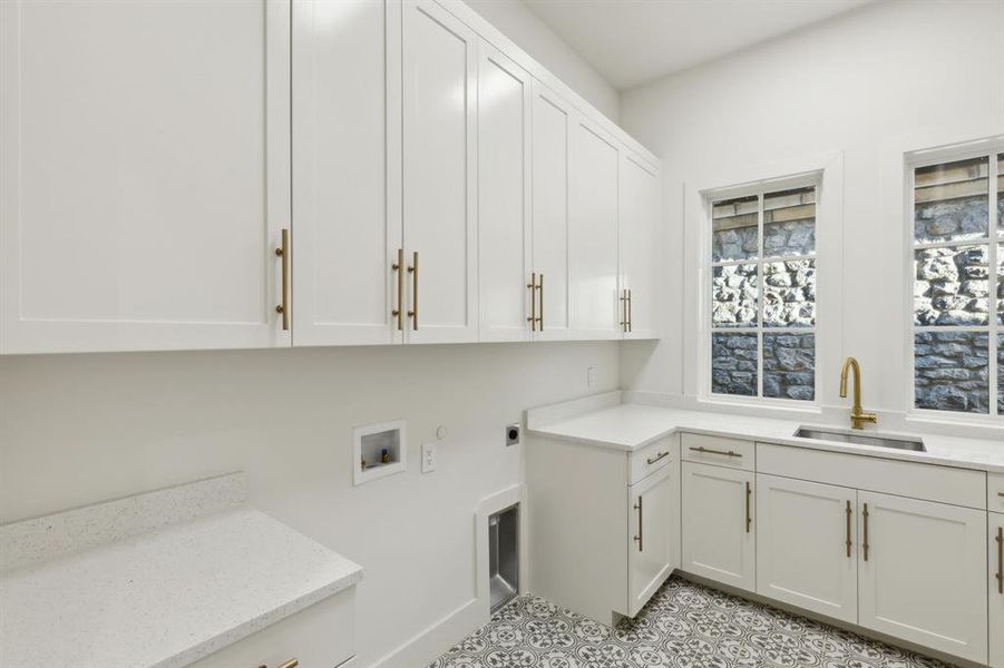 Laundry area featuring cabinets, washer hookup, electric dryer hookup, sink, and light tile flooring