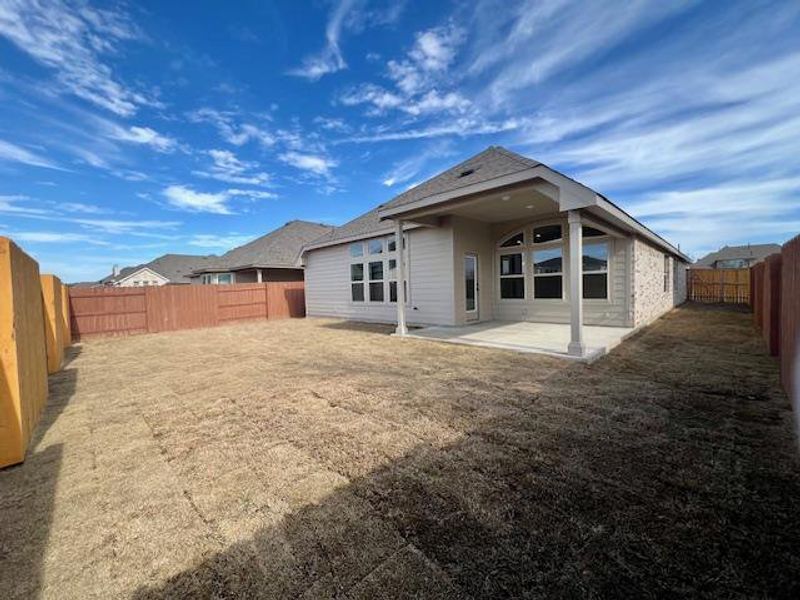 Rear view of house with a shingled roof, a patio area, a fenced backyard, and a lawn Rear view of house with a shingled roof, a patio area, a fenced backyard, and a lawn
