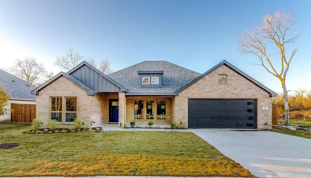 View of front of home with a front yard and a garage