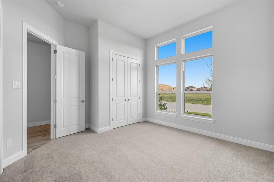 Unfurnished bedroom with light carpet and a closet
