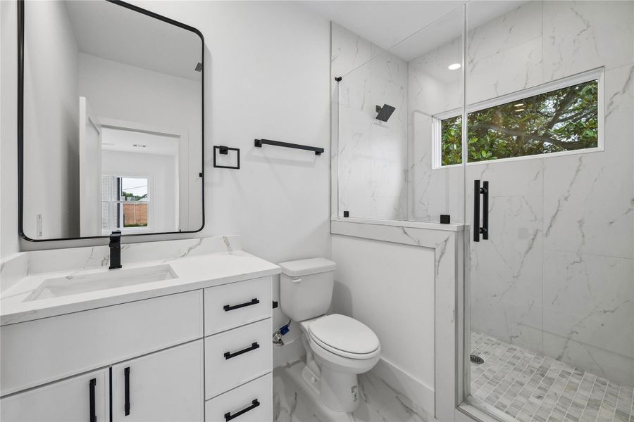 The full bathroom within the detached garage apartment features contemporary finishes, quartz surfaces, modern fixtures, and a walk-in shower. Designed to support long-term guest use or future independent living flexibility, the space complements the apartment’s overall functionality.