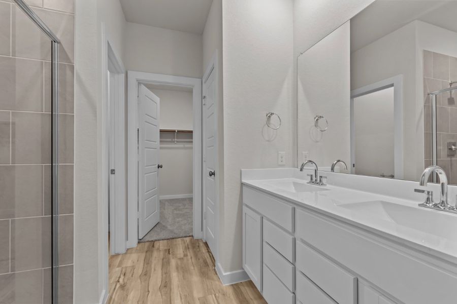 A bathroom with a sink and a shower unit.