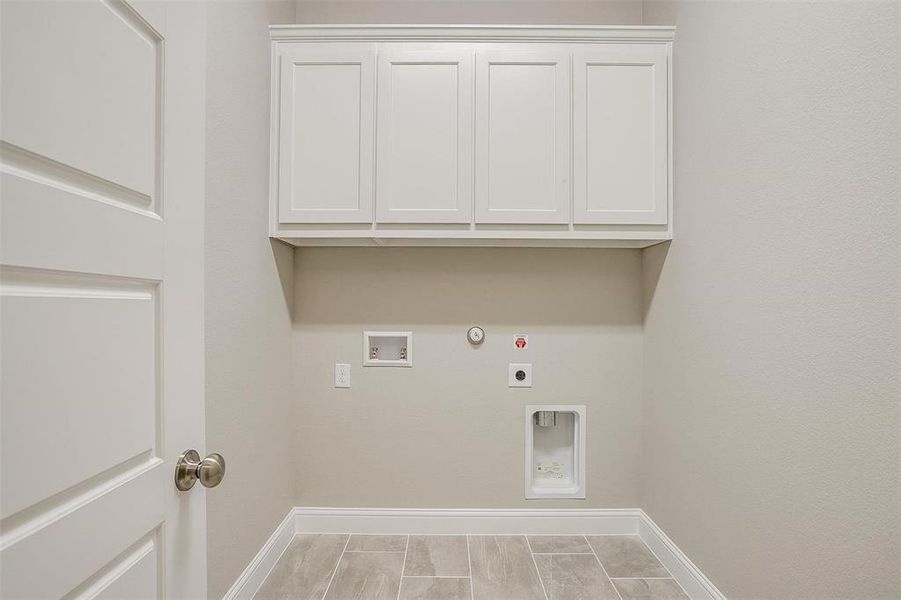 Laundry room featuring hookup for a washing machine, gas dryer hookup, electric dryer hookup, and cabinets