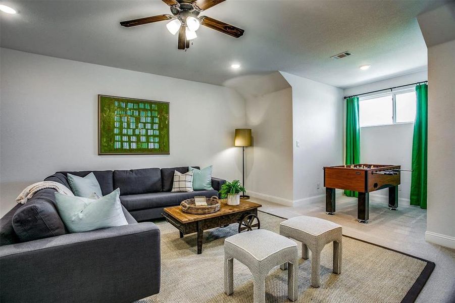 Living room featuring light colored carpet and ceiling fan