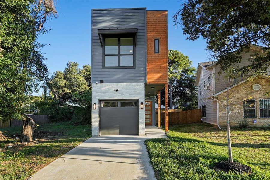 Modern home featuring a front lawn and a garage