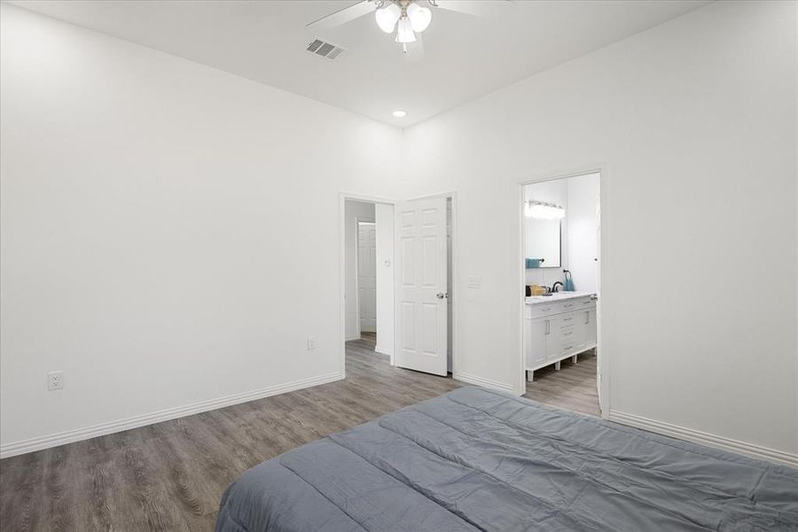 Bedroom with hardwood / wood-style floors, sink, connected bathroom, and ceiling fan