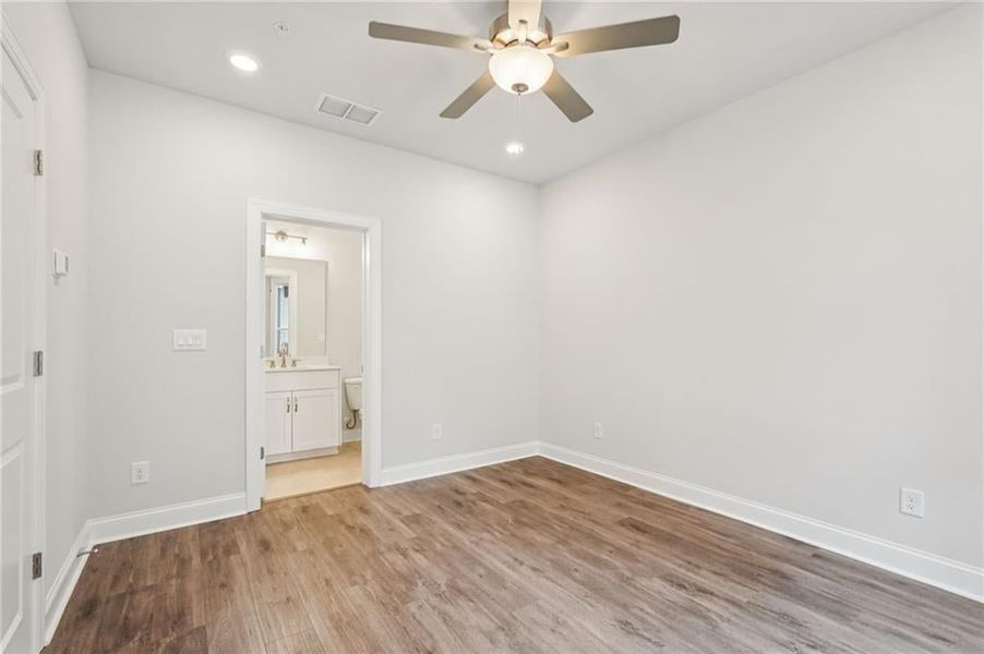 Unfurnished bedroom with recessed lighting, light wood-type flooring, ceiling fan, and connected bathroom