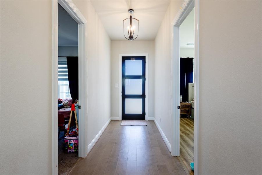 Entryway featuring wood finished floors and a chandelier
