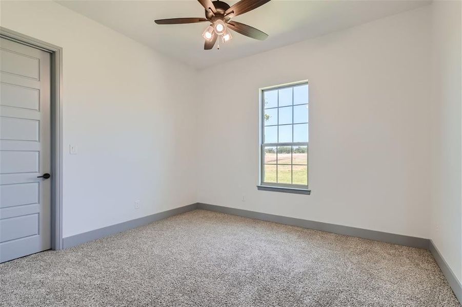 Unfurnished room featuring carpet floors and ceiling fan