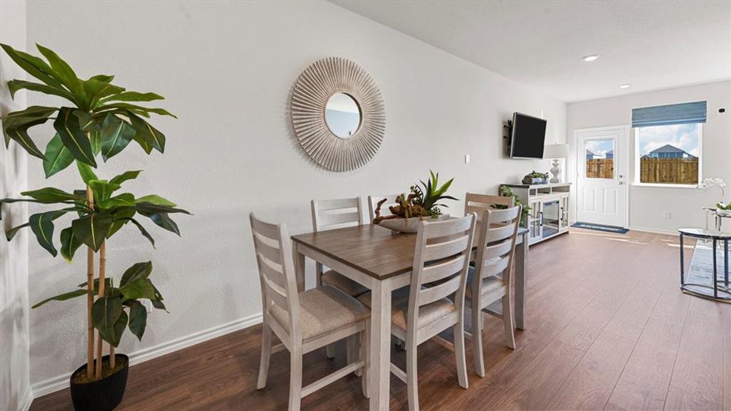 Dining space with dark wood-style flooring and baseboards