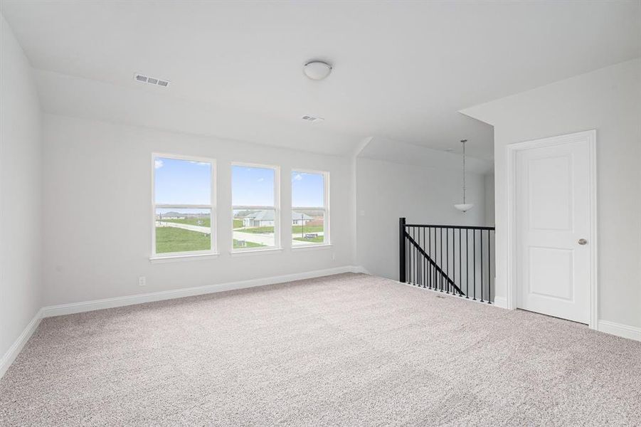 Carpeted empty room featuring baseboards and visible vents