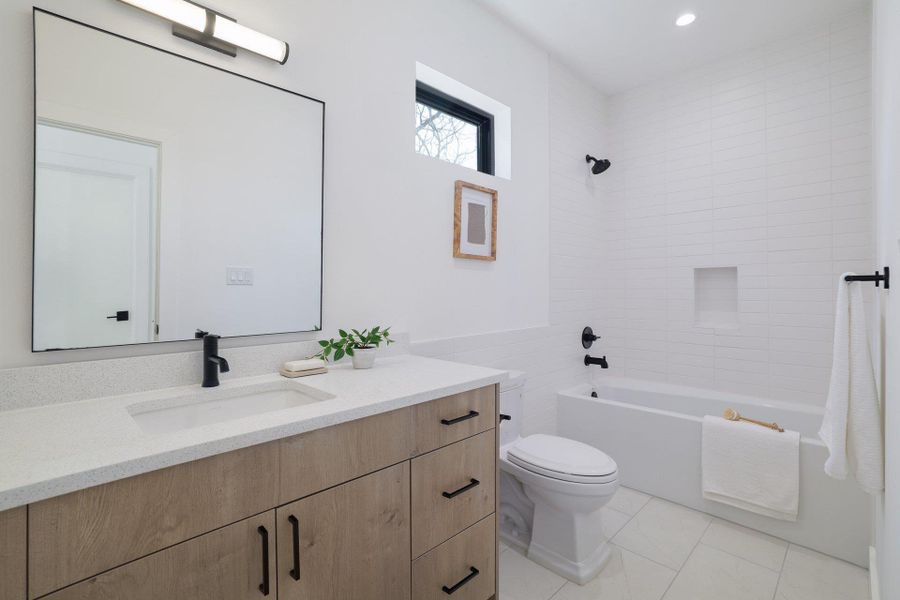 Bathroom with bathtub / shower combination, vanity, and light tile patterned flooring