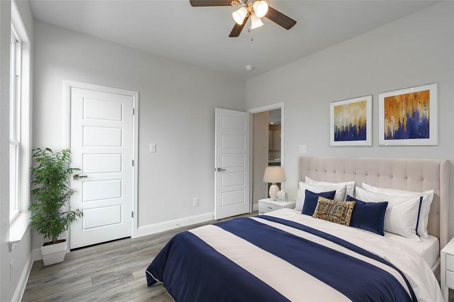 Bedroom with multiple windows, ceiling fan, and light hardwood / wood-style floors