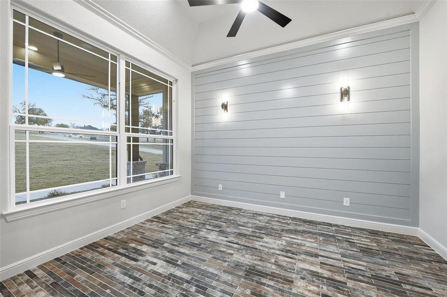 Unfurnished room featuring ceiling fan and wooden walls Unfurnished room featuring ceiling fan and wooden walls
