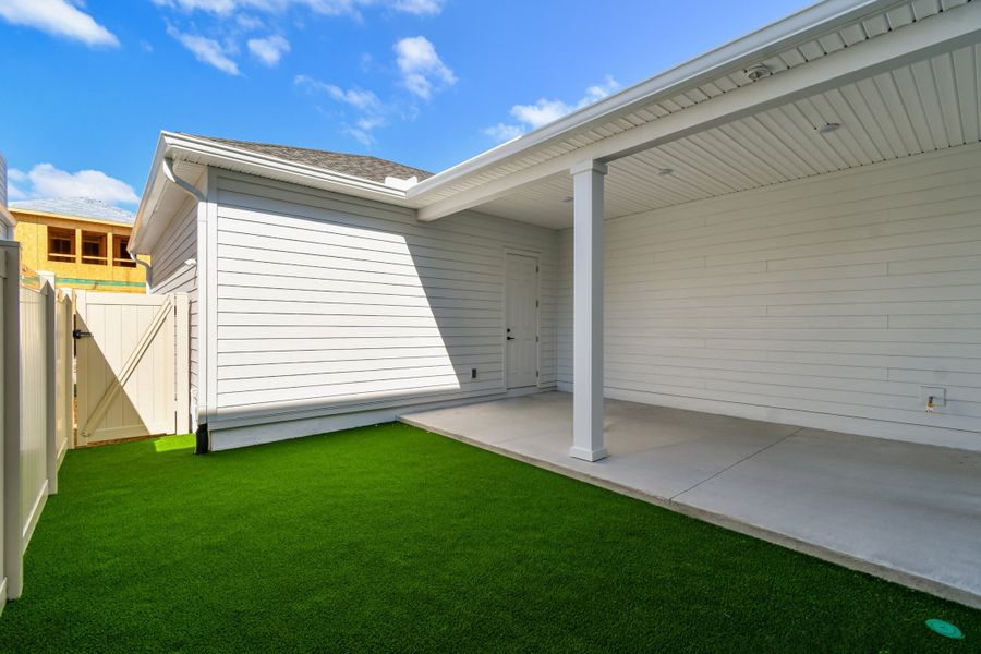 Exterior details and patio area of a home in Seven Pines 24' Rear Entry Townhomes, Jacksonville (Image 4).