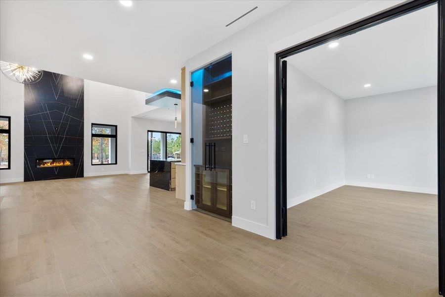 Entryway showcasing the wine case, flex office/ sitting room, and open living dining areas. Entryway showcasing the wine case, flex office/ sitting room, and open living dining areas.