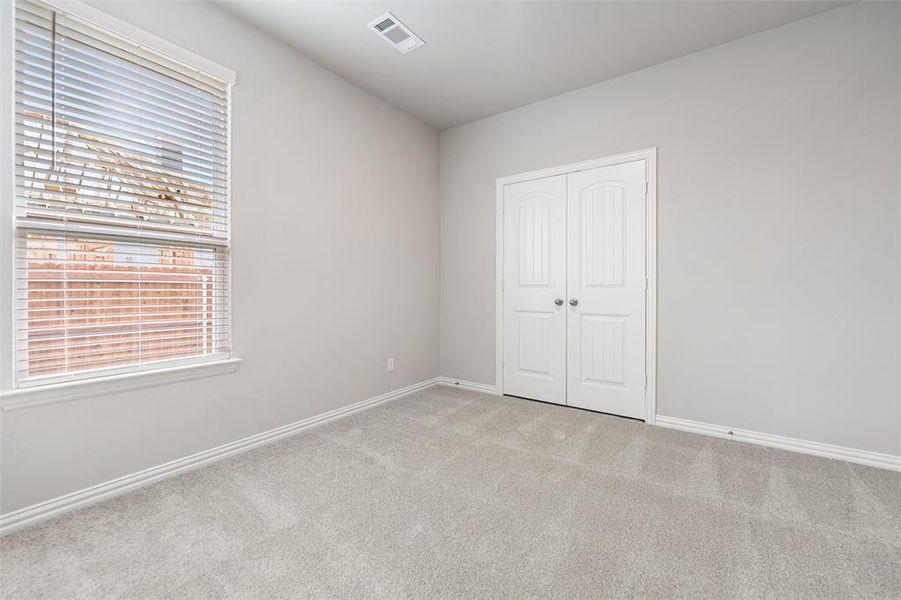 Unfurnished bedroom with carpet and a closet Unfurnished bedroom with carpet and a closet