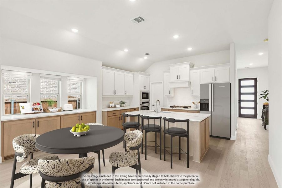 Open kitchen with white upper cabinets, wood lower cabinets, center island, and adjacent dining area with round table