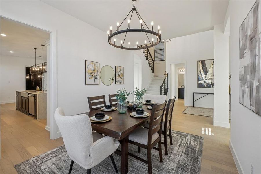 Dining area with a chandelier, stairs, light wood-type flooring, and recessed lighting Dining area with a chandelier, stairs, light wood-type flooring, and recessed lighting