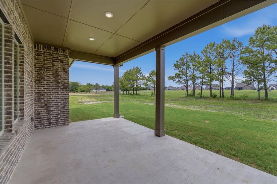 Covered patio featuring a concrete slab, recessed lighting, and brick exterior walls