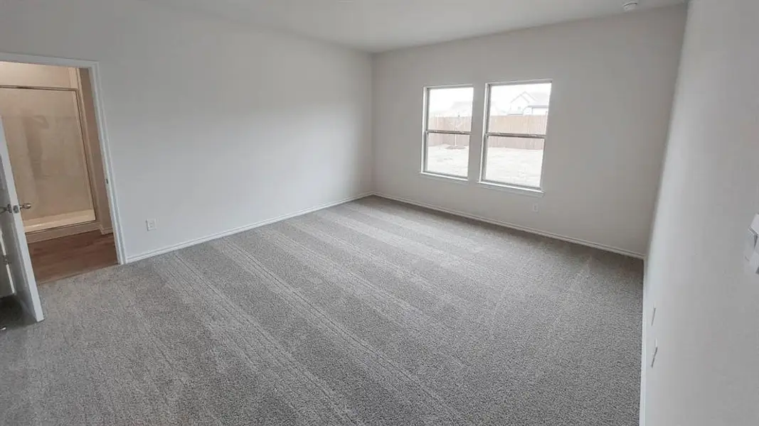 Unfurnished room with light carpet and baseboards Unfurnished room with light carpet and baseboards