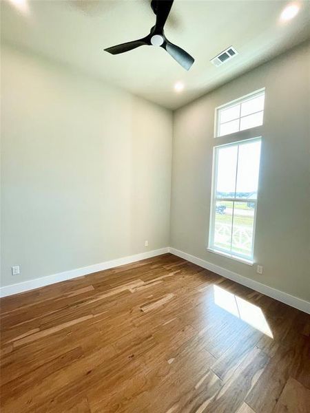 Empty room featuring ceiling fan, light wood-style flooring, and recessed lighting