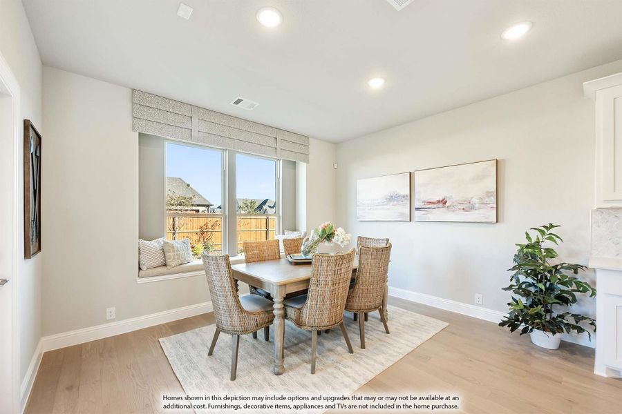 Dining room with wood table, wicker chairs, window seat, and light hardwood floors