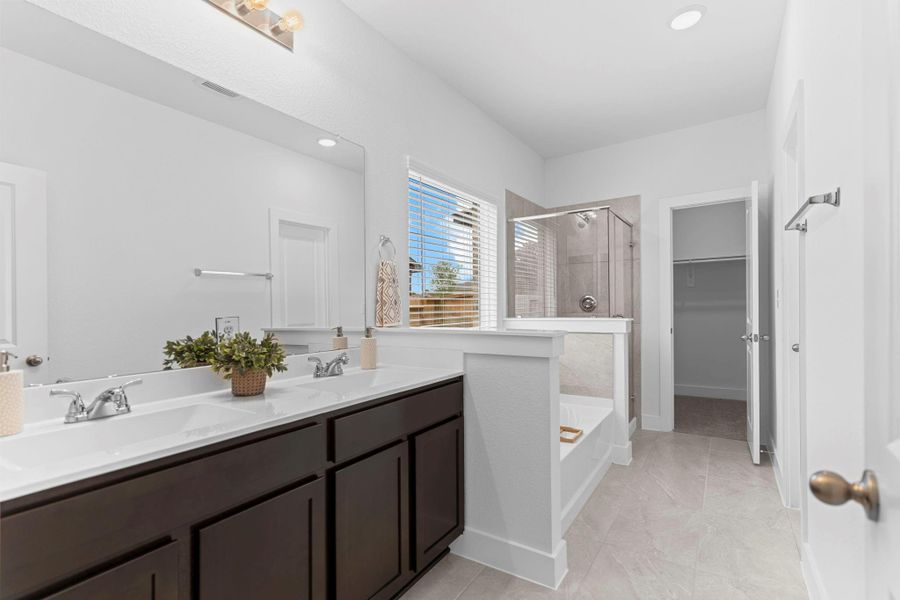 The en-suite primary bathroom features dual vanities with cultured marble countertops, elegant lighting, and sleek dark cabinetry—designed for both beauty and function. **Image Representative of Plan Only and May Vary as Built**.
