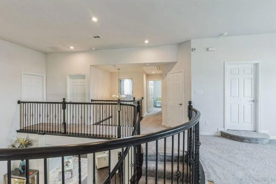 Corridor featuring a chandelier and carpet floors