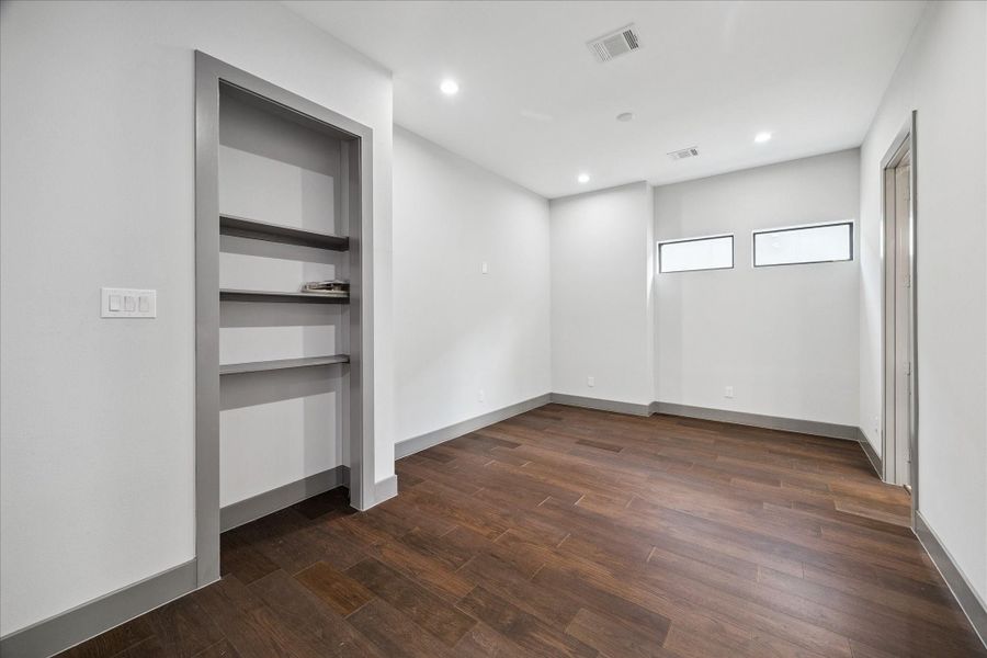 Designed for versatility, this bonus room includes built-in shelving and recessed lighting, making it a great option for a home office, playroom, or media space. The neutral palette and hardwood flooring allow for easy personalization to fit your needs.