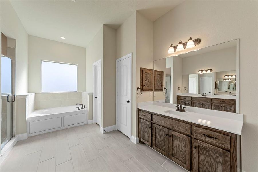 Bathroom featuring vanity and shower with separate bathtub