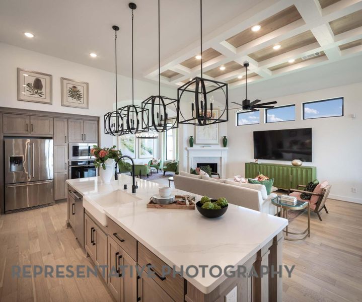 Kitchen with a fireplace, stainless steel appliances, a wealth of natural light, and coffered ceiling Kitchen with a fireplace, stainless steel appliances, a wealth of natural light, and coffered ceiling