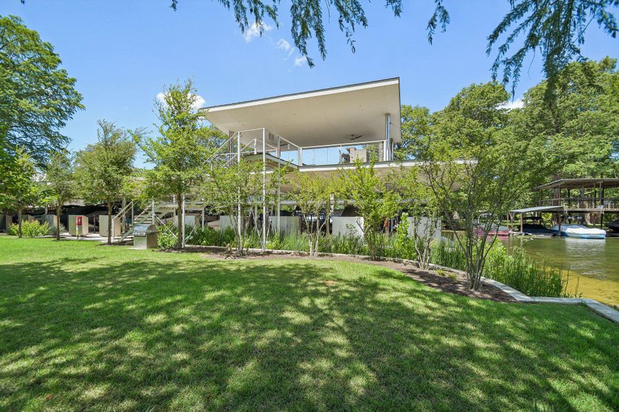 Mature trees shade a manicured lawn leading directly to a multi-level waterfront boat dock. Mature trees shade a manicured lawn leading directly to a multi-level waterfront boat dock.