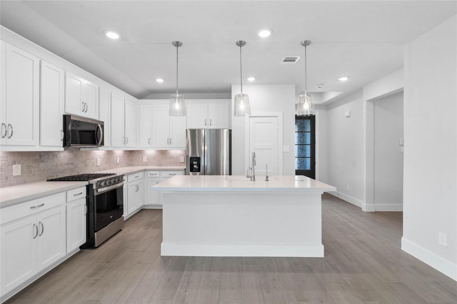 This modern kitchen island features a polished quartz countertop with a sink, complemented by a Moen Sleek stainless faucet with DuPure water filtration system.