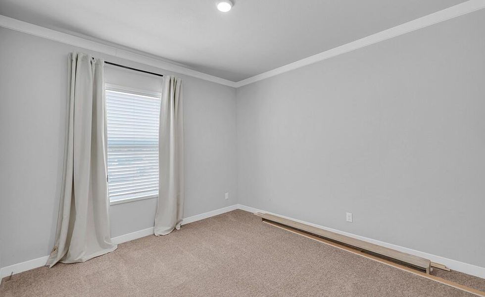 Empty room featuring ornamental molding and light carpet Empty room featuring ornamental molding and light carpet