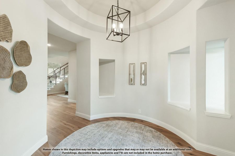 Foyer with round tray ceiling, pendant light fixture, hardwood floors, and view of staircase beyond arched hallway. Foyer with round tray ceiling, pendant light fixture, hardwood floors, and view of staircase beyond arched hallway.