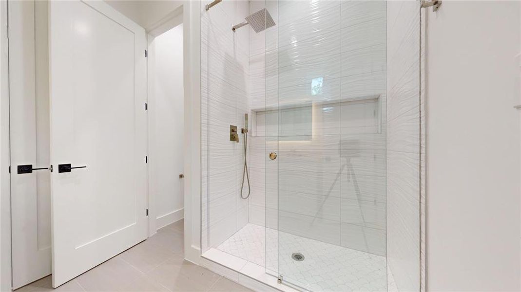 Bathroom with a walk in shower and light tile patterned floors