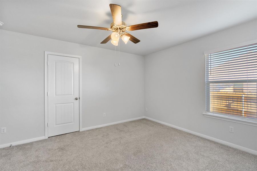 Spare room featuring light carpet and a ceiling fan