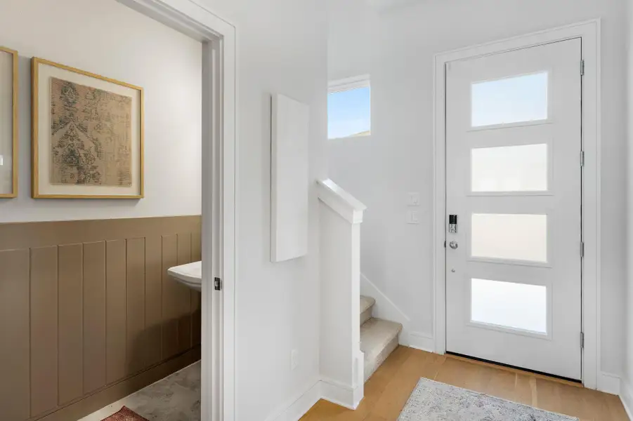 Entryway featuring light wood-type flooring and stairway Entryway featuring light wood-type flooring and stairway