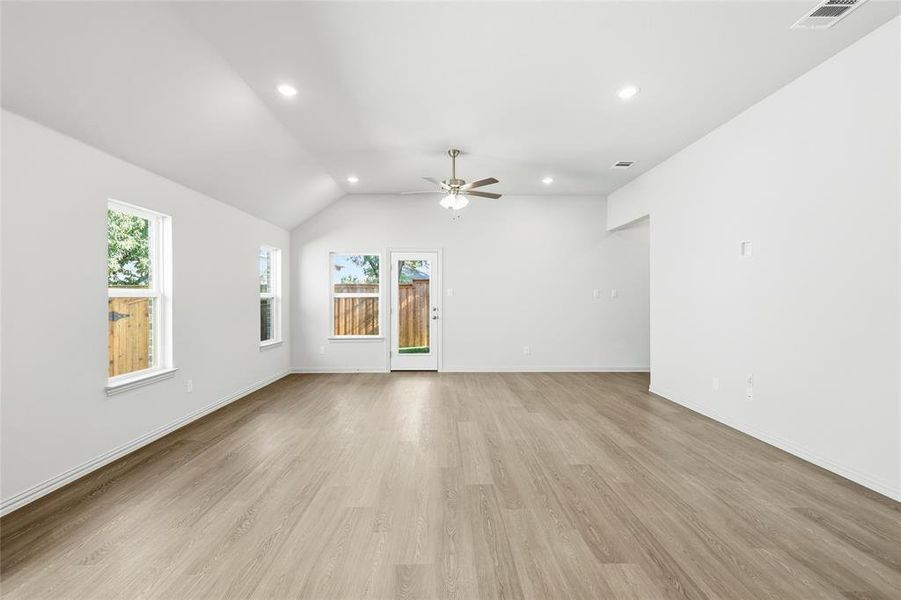 Spare room featuring light wood-type flooring, vaulted ceiling, recessed lighting, and ceiling fan