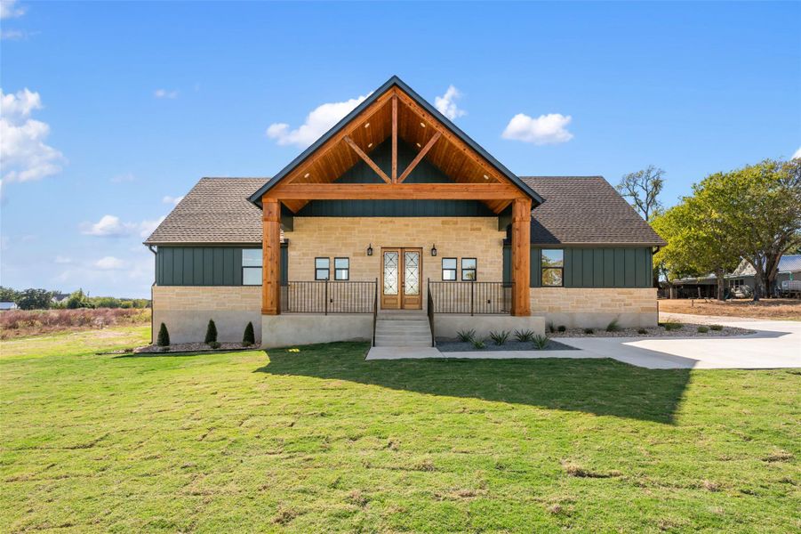 View of front of home with board and batten siding, a porch, and a front yard