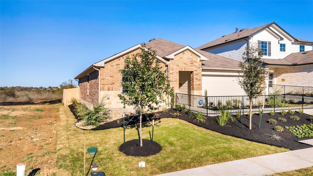 Front exterior of a new home in Carillon, Manor, TX, highlighting curb appeal (Image 21). Front exterior of a new home in Carillon, Manor, TX, highlighting curb appeal (Image 21).