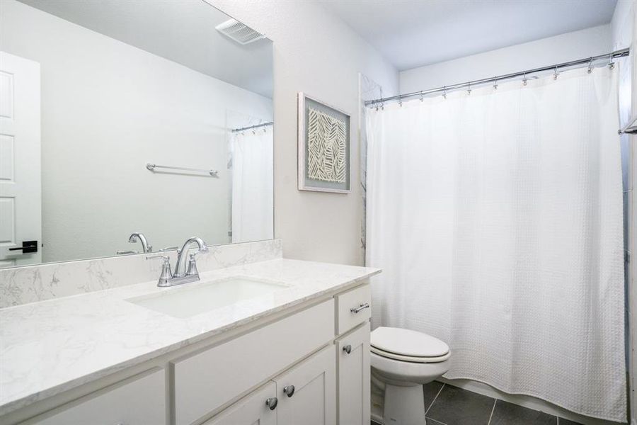 Full Bath Convenience - An additional full bath with quartz-look counters, updated lighting, and understated tile work—well positioned for upstairs guests or bedrooms. Full Bath Convenience - An additional full bath with quartz-look counters, updated lighting, and understated tile work—well positioned for upstairs guests or bedrooms.