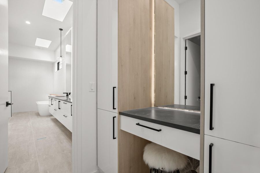 Full bath featuring vanity, a skylight, and a freestanding tub