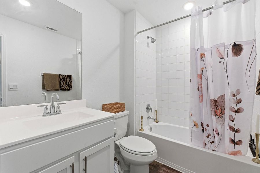 Full bathroom with vanity, shower / bath combination with curtain, and recessed lighting